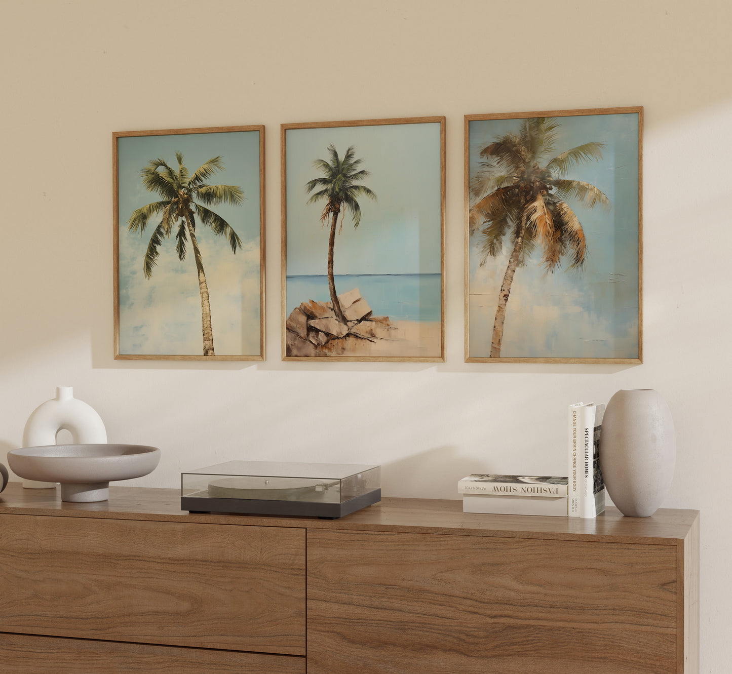 Three framed pictures of palm trees on a wall above a wooden sideboard with decorative items.