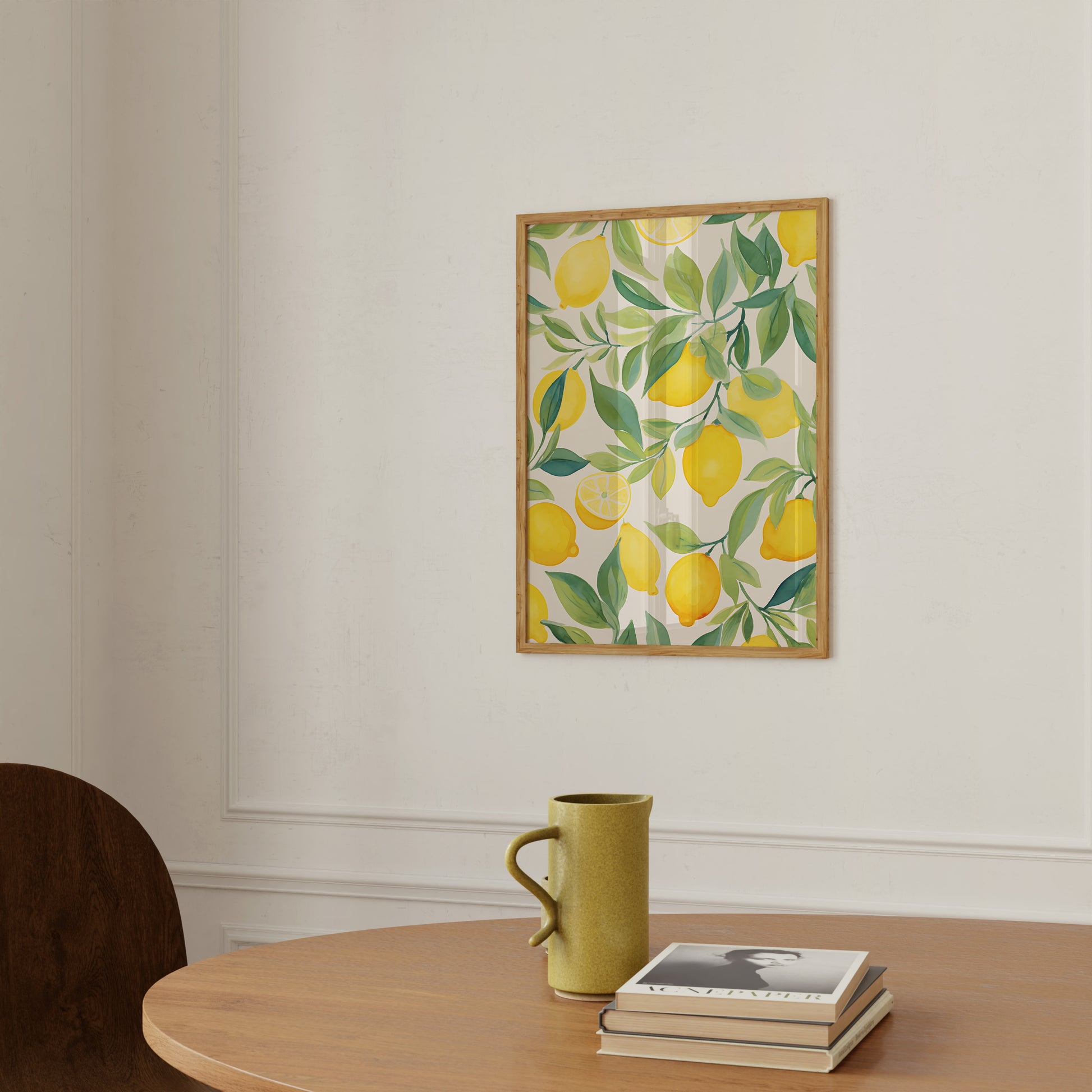 A framed lemon-themed artwork above a table with a mug and books.