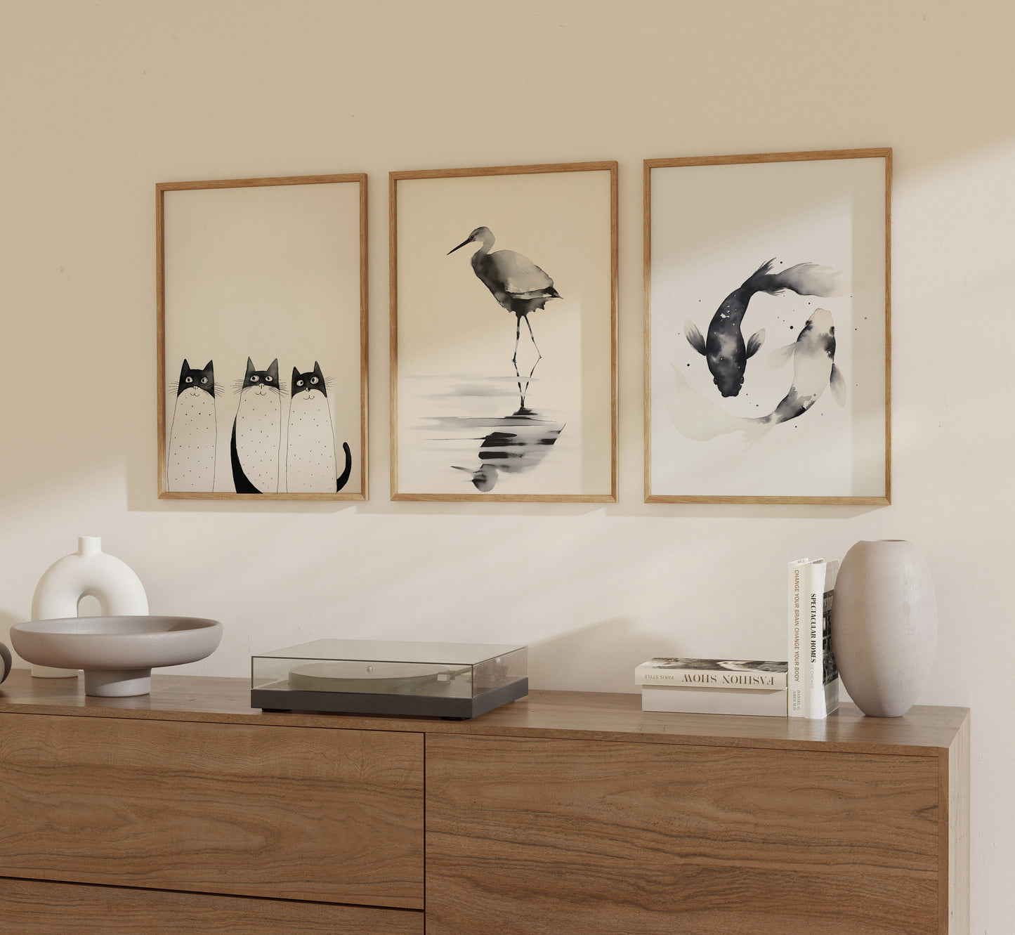 Three framed art pieces on a wall above a wooden sideboard with decorative objects.