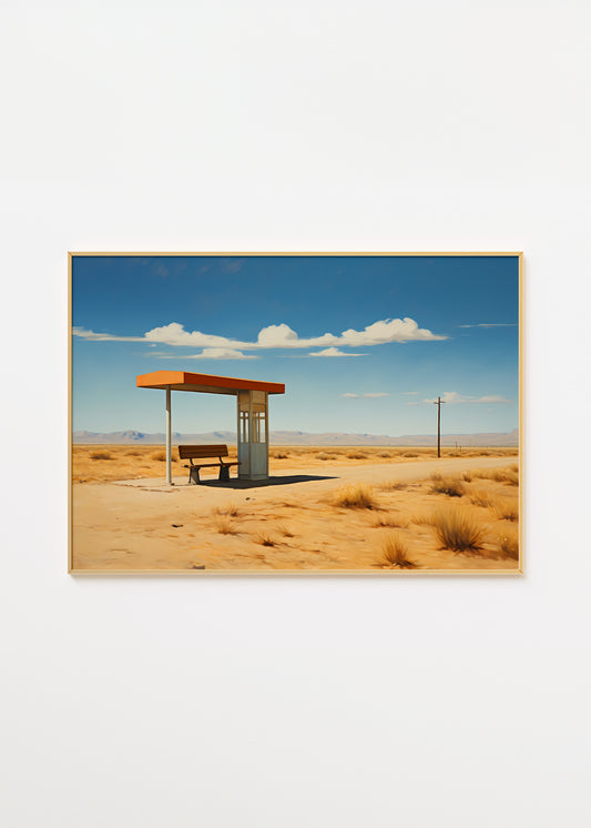 A framed photograph of a solitary bus stop in a desert landscape under a blue sky with clouds.