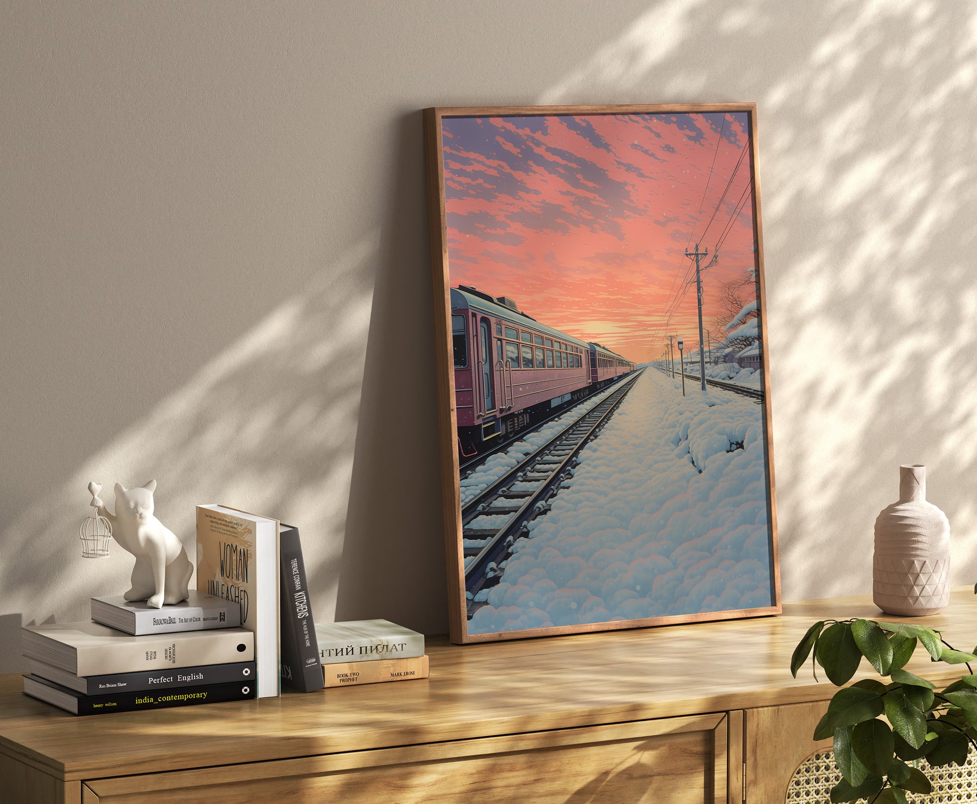 A framed poster of a train at sunset on a snow-covered track, displayed in a cozy interior.