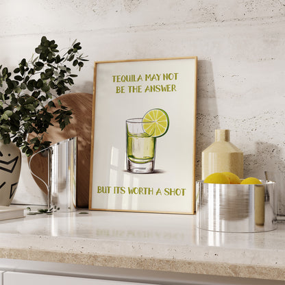 A framed poster with a pun about tequila on a kitchen counter with decor.