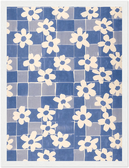 A framed textile art piece with a pattern of white flowers on a blue grid background.