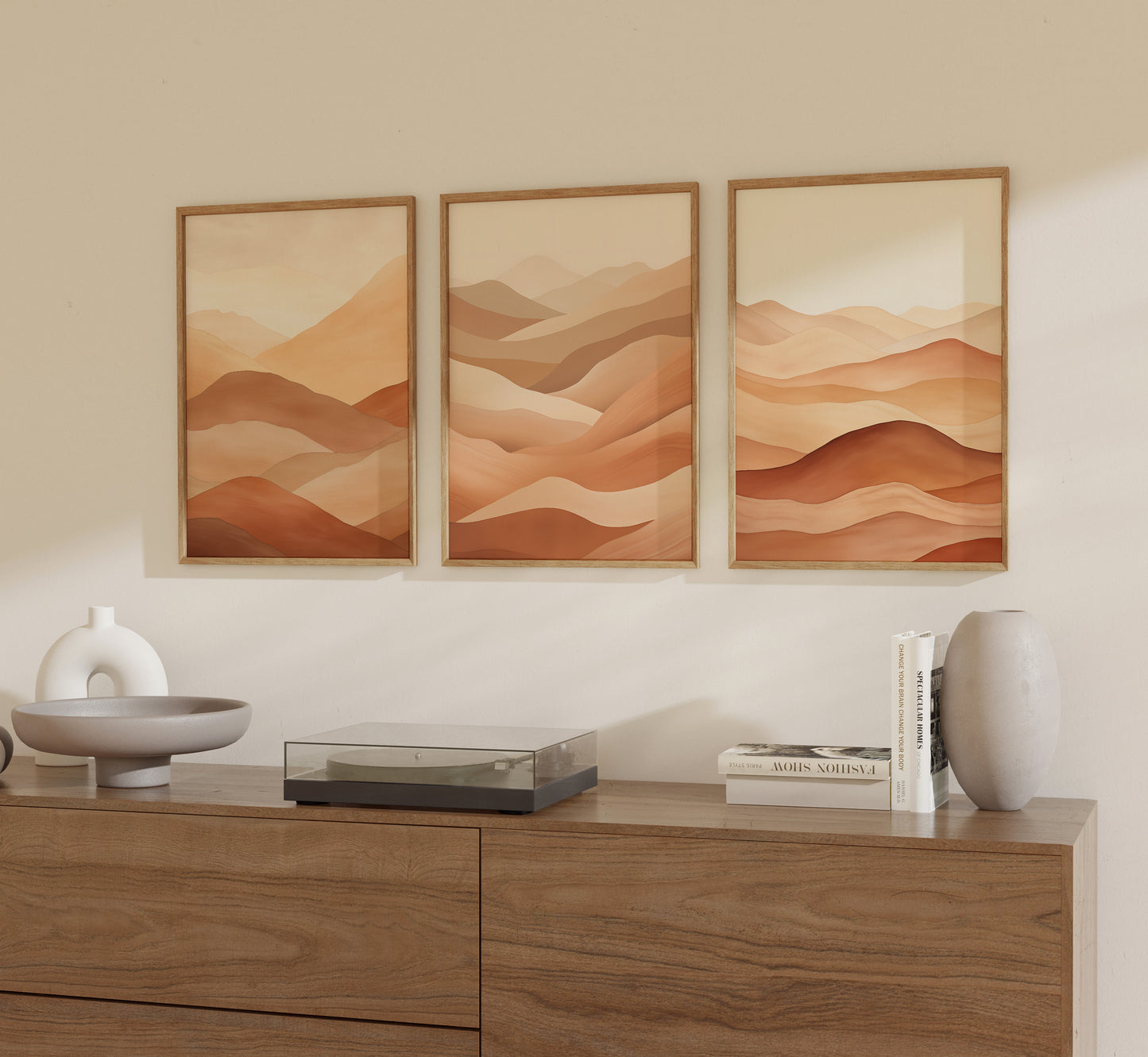 Three framed desert landscape prints above a wooden dresser with decorative items.
