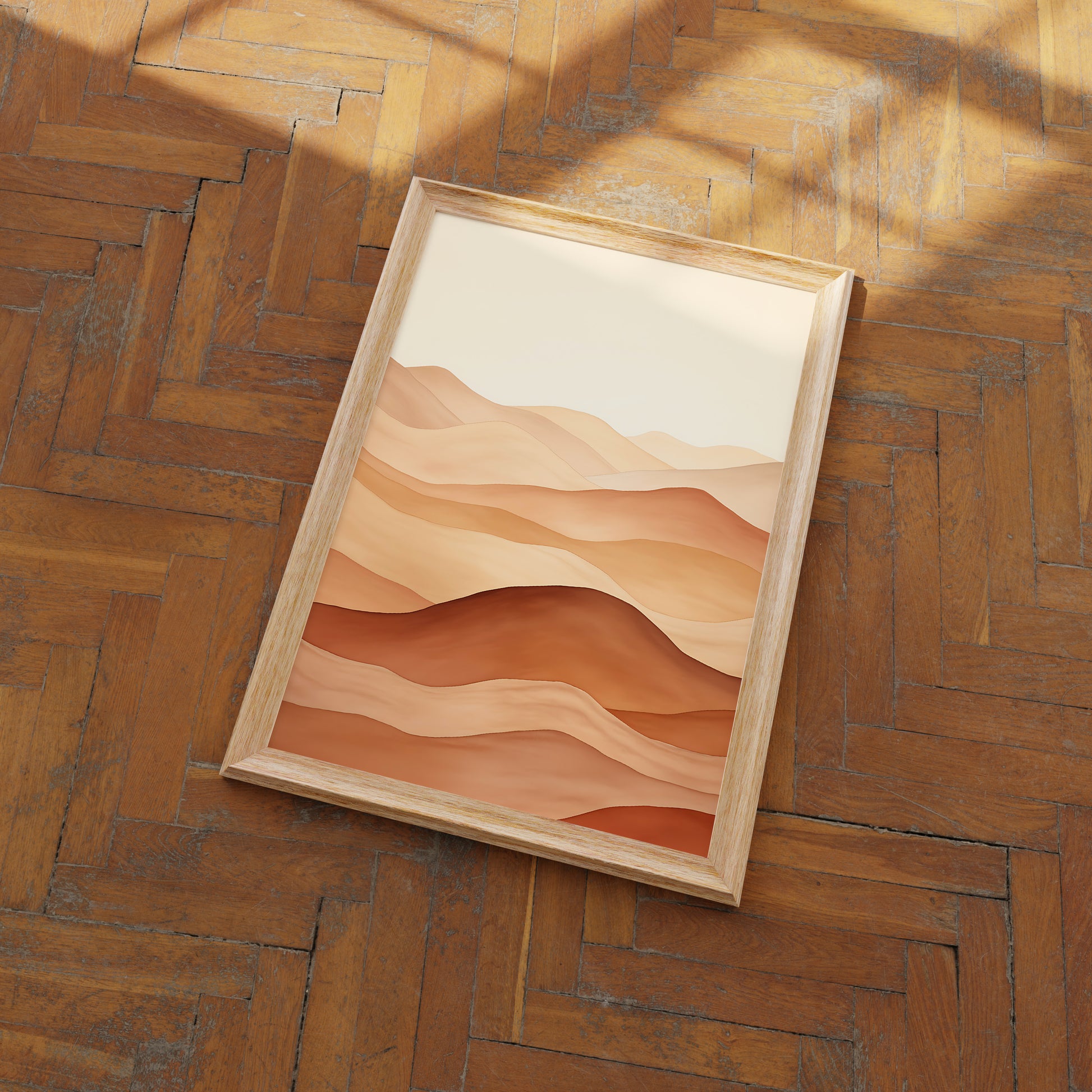 Wooden frame with an abstract desert landscape print on a herringbone parquet floor.