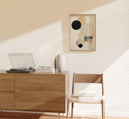 Modern room with a turntable on a wooden cabinet and abstract art on the wall.