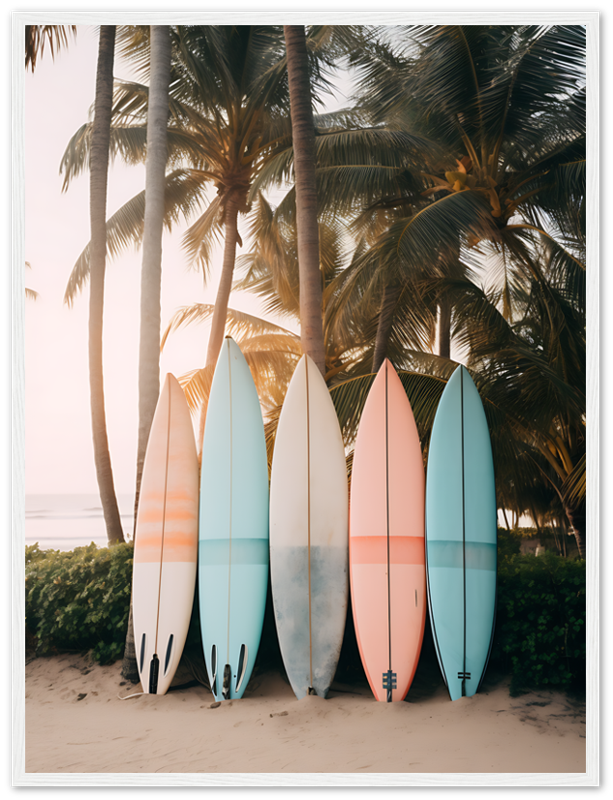 Five surfboards standing upright on a beach at sunset with palm trees in the background.