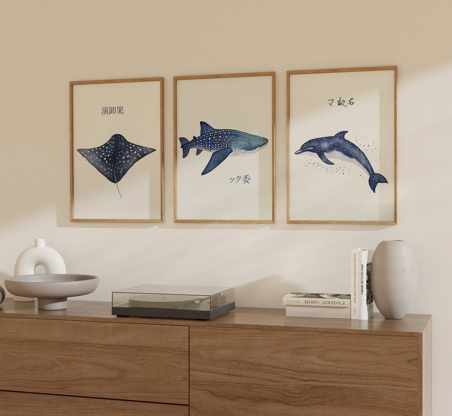 Three framed illustrations of marine animals on a wall above a wooden sideboard.
