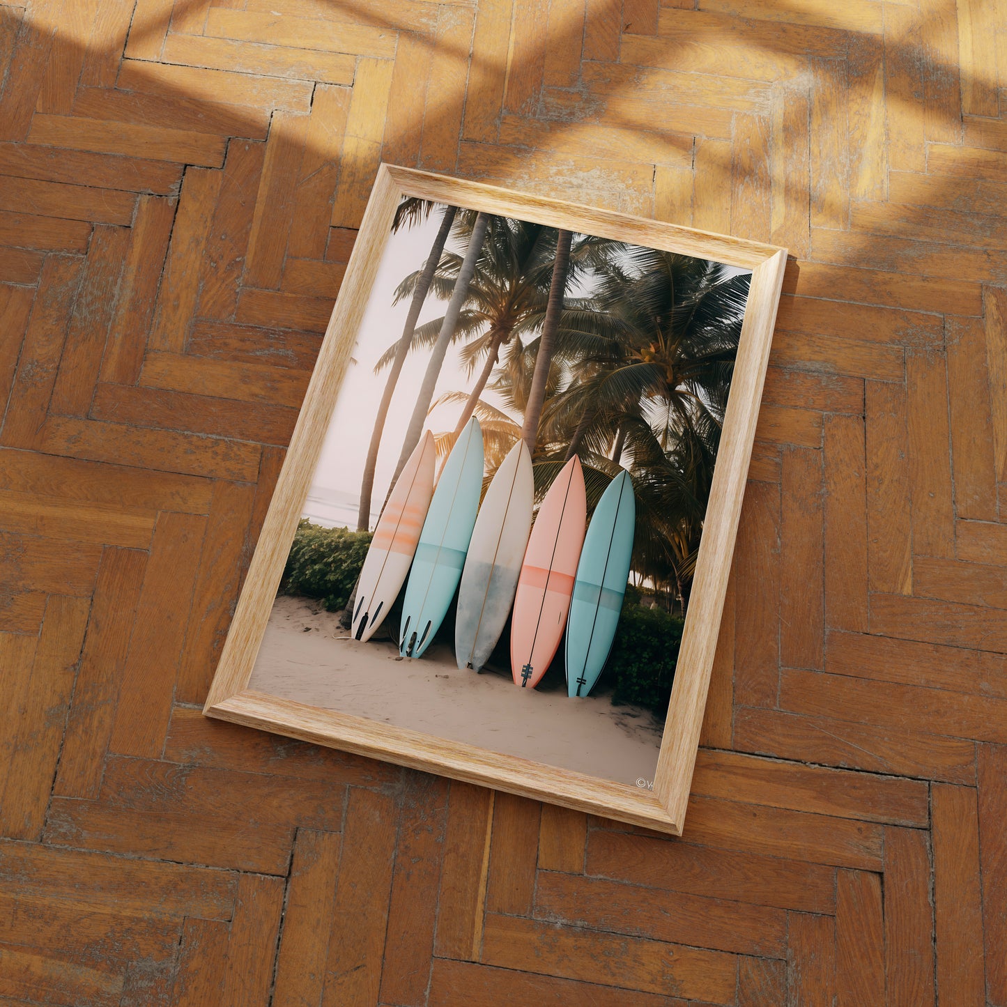 A framed picture of colorful surfboards leaned against palm trees on a beach, hung on a stone wall.