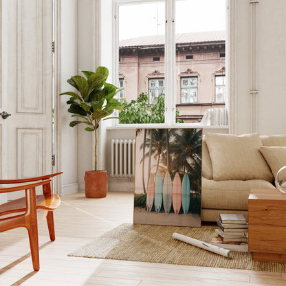 A bright living room with a beige sofa, wooden furniture, and a large plant beside a canvas print.