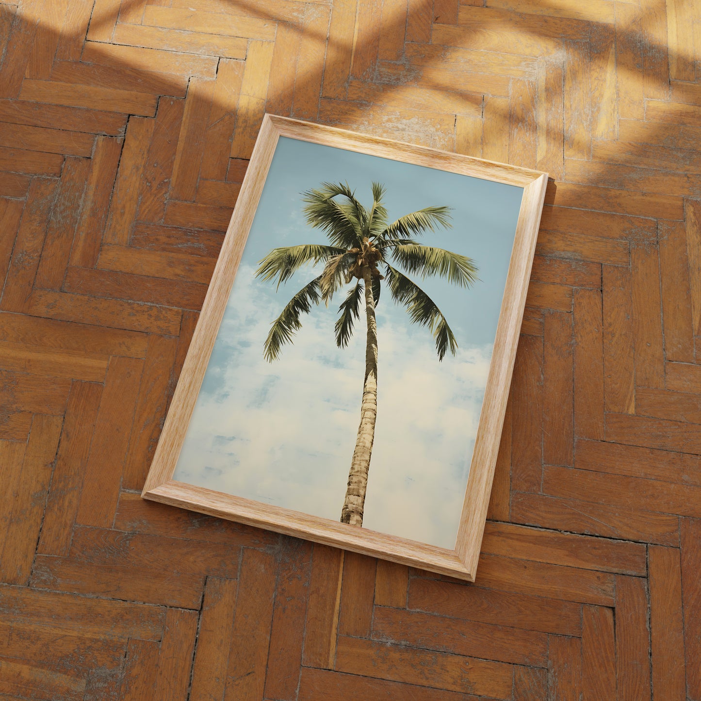 A framed picture of a palm tree on a wooden floor.
