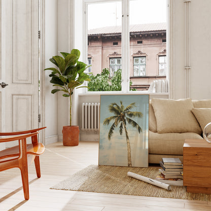 A cozy living room with a sofa, wooden table, plant, and a picture of a palm tree leaning against the wall.