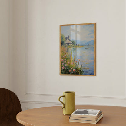 A serene lakeside painting above a table with a yellow mug and books.