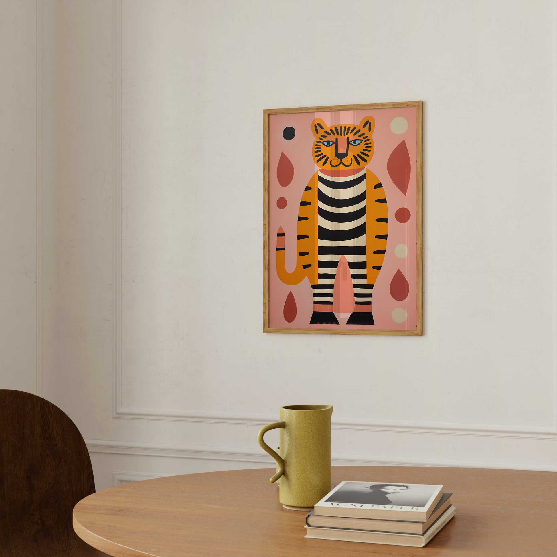 Colorful abstract cat painting on a wall in a cozy room with a mug and books on a table.