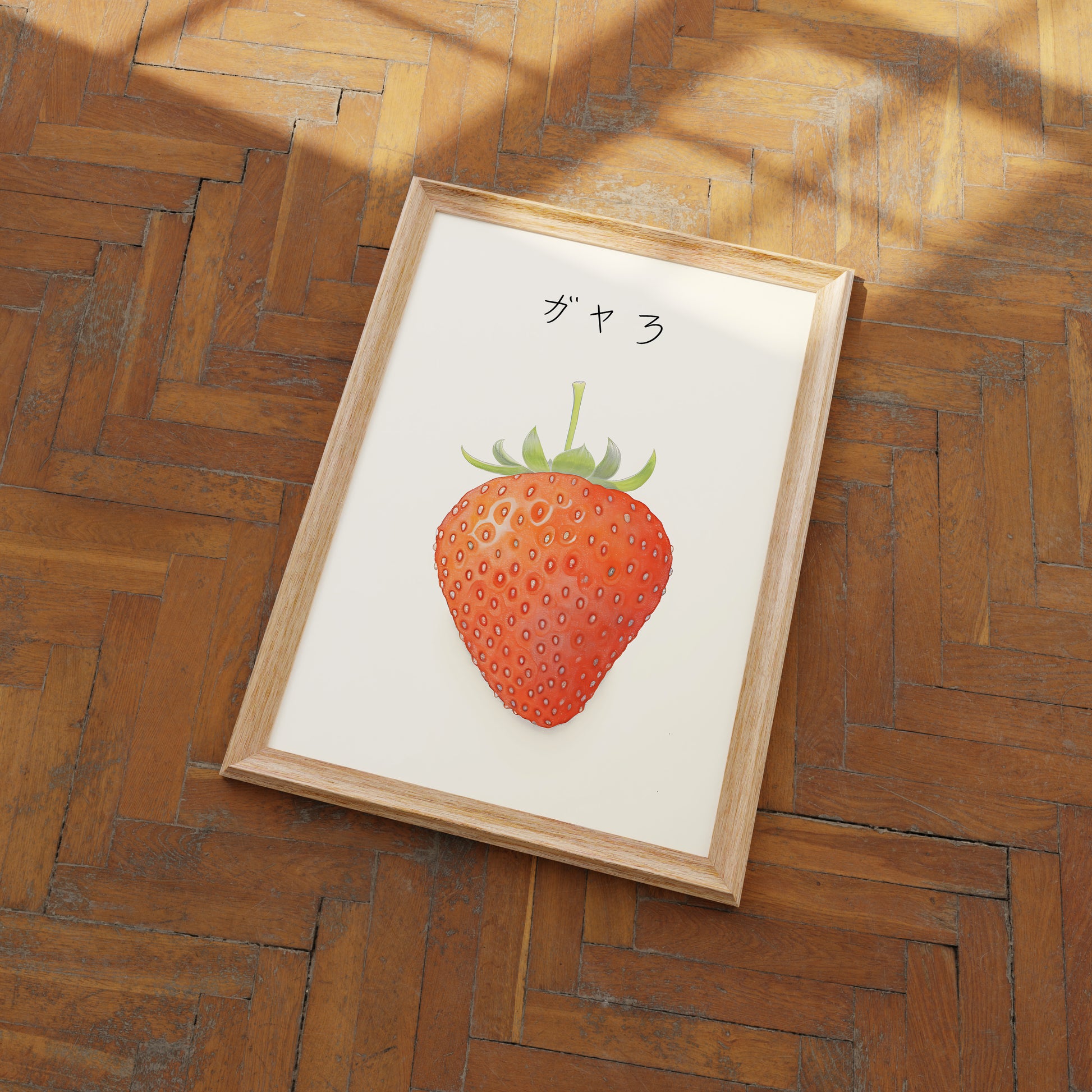 A framed illustration of a strawberry on a wooden floor.