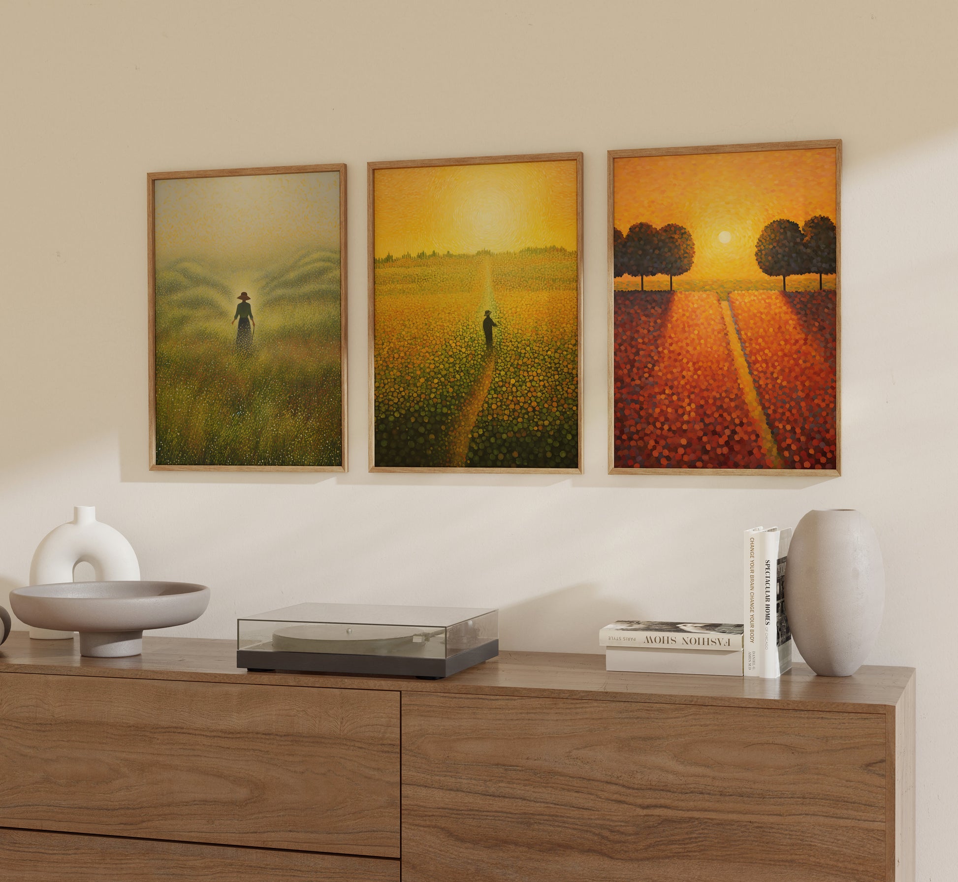 Three landscape paintings on a wall depicting sunlit fields and trees.