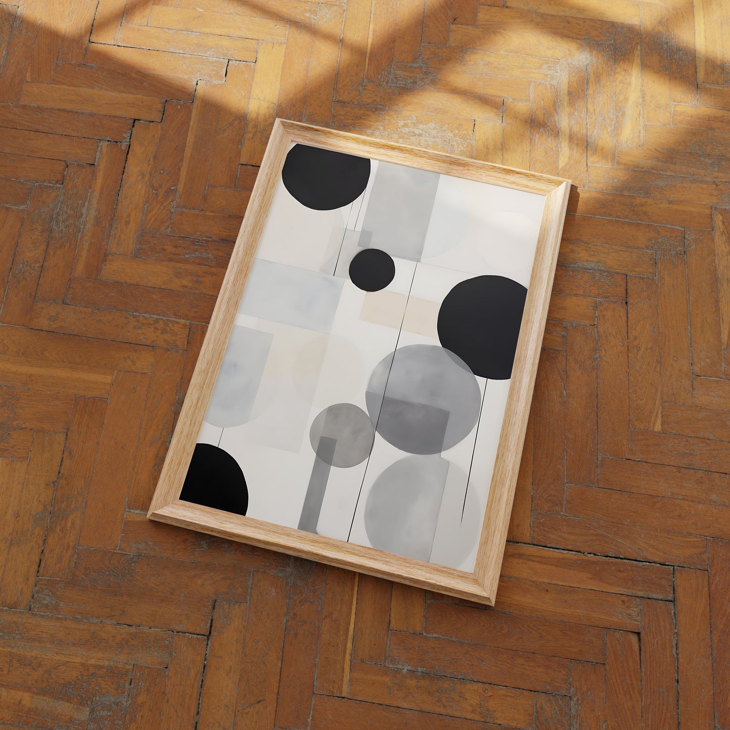 Abstract art with black and white circles in a wooden frame on a parquet floor.