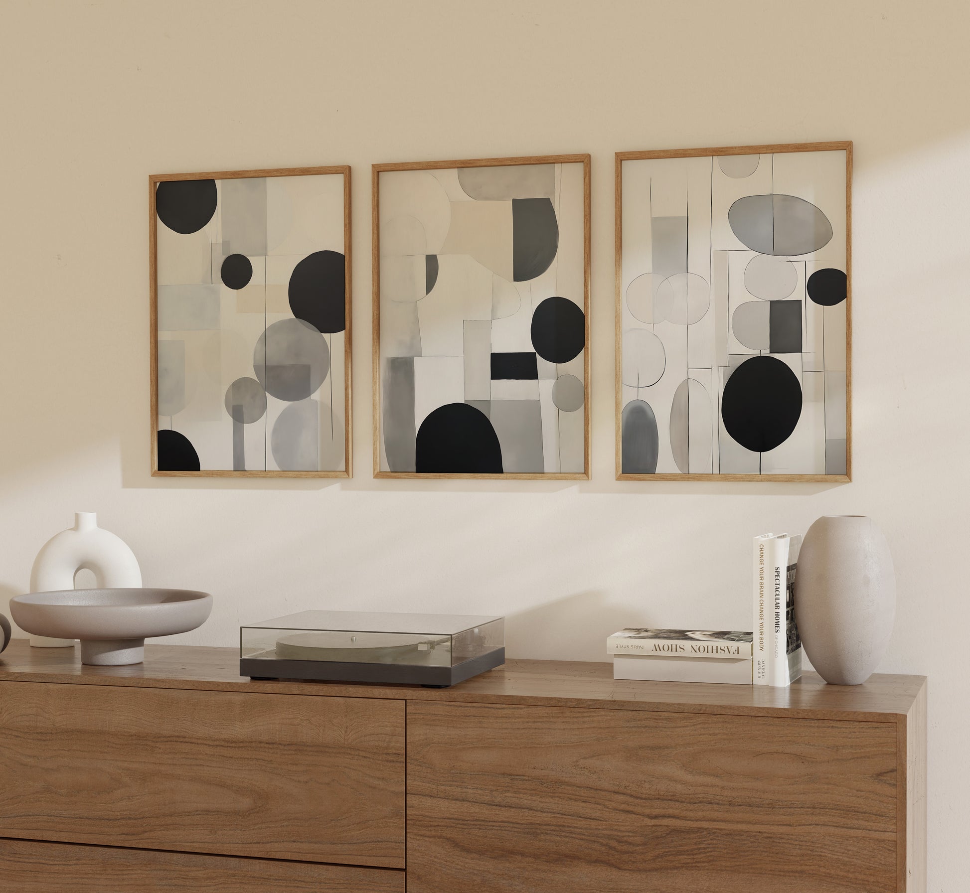 Three abstract framed artworks on a wall above a wooden sideboard with decorative items.