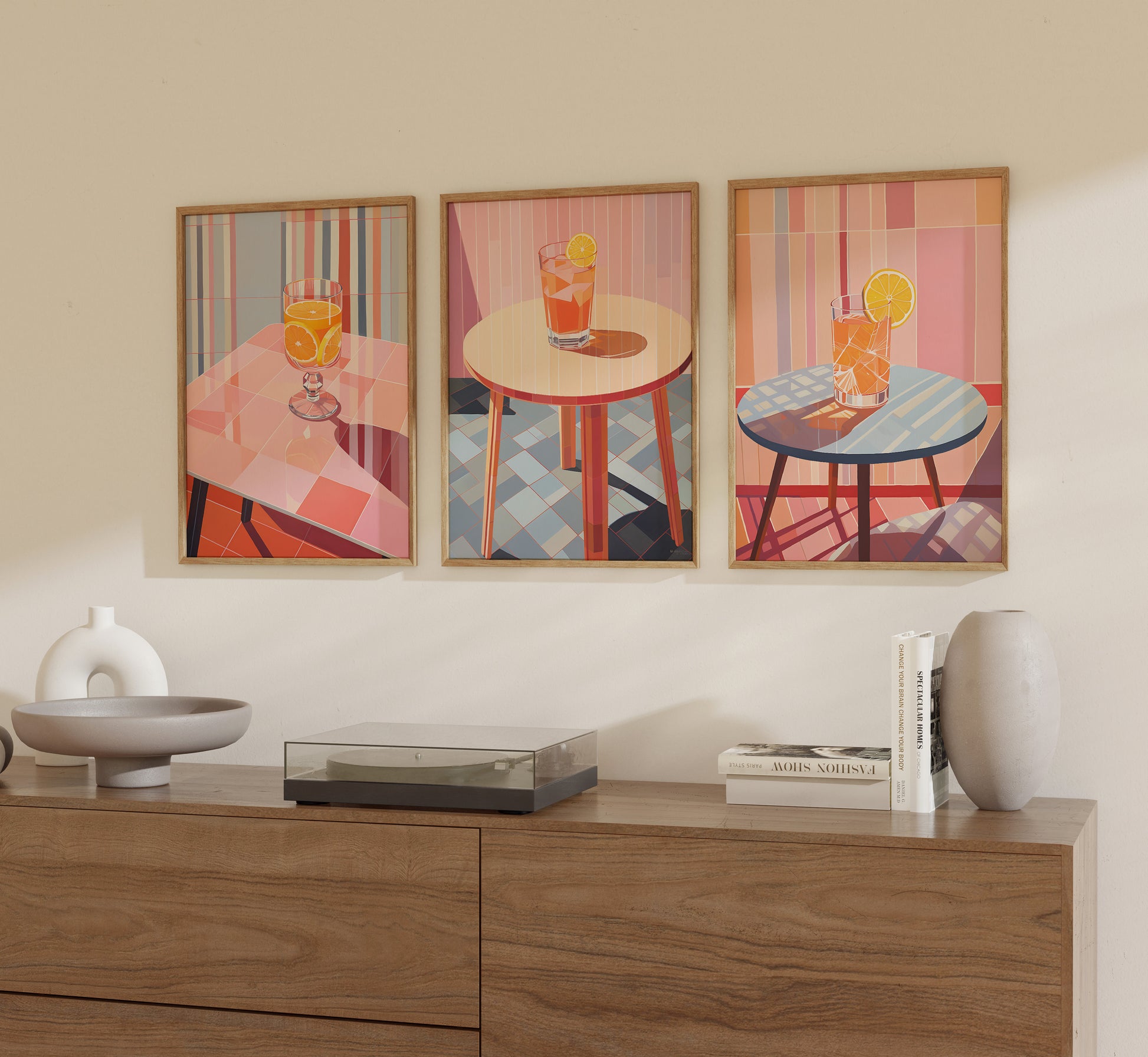 Three geometric art prints depicting cocktails on tables, displayed above a wooden credenza.