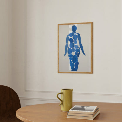 Modern art piece depicting a blue human figure on a wall above a table with a mug and books.