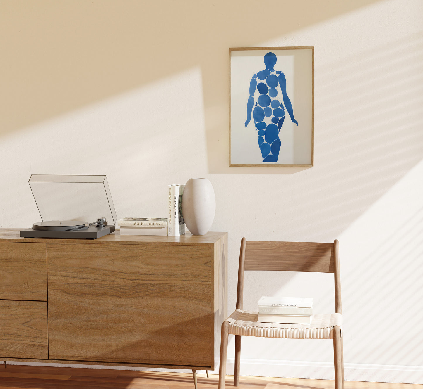 A modern room with a sideboard, chair, record player, and abstract art on the wall.