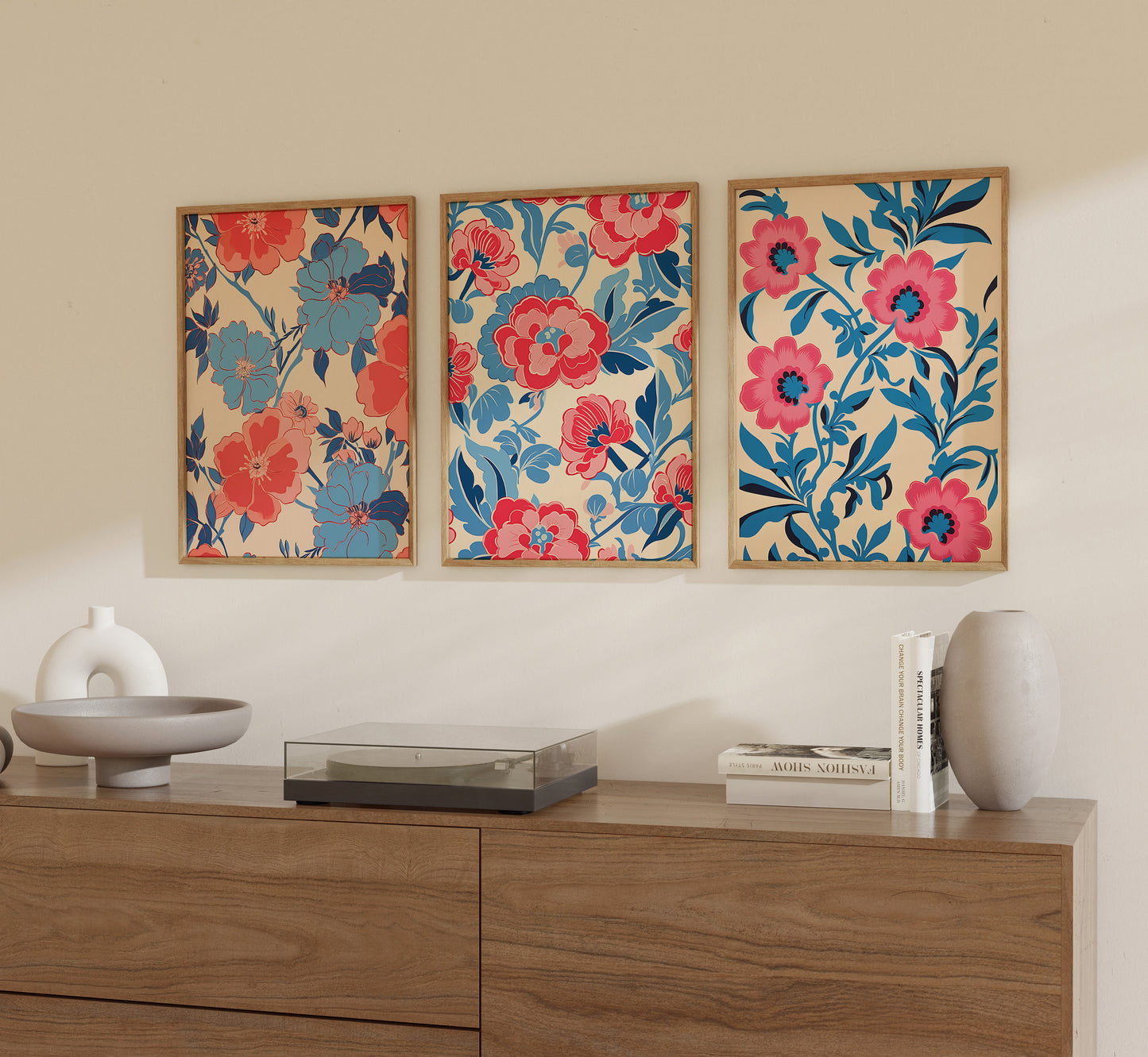 Three vibrant floral paintings on a wall above a wooden sideboard with decorative items.