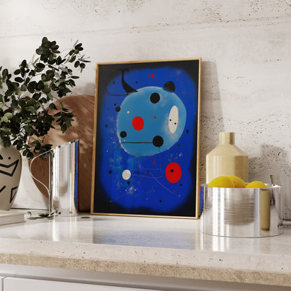 Abstract blue art with red and black dots framed on a kitchen countertop.