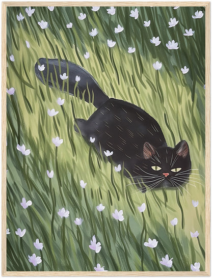 A painting of a black cat walking through a green field with white flowers, framed in wood.