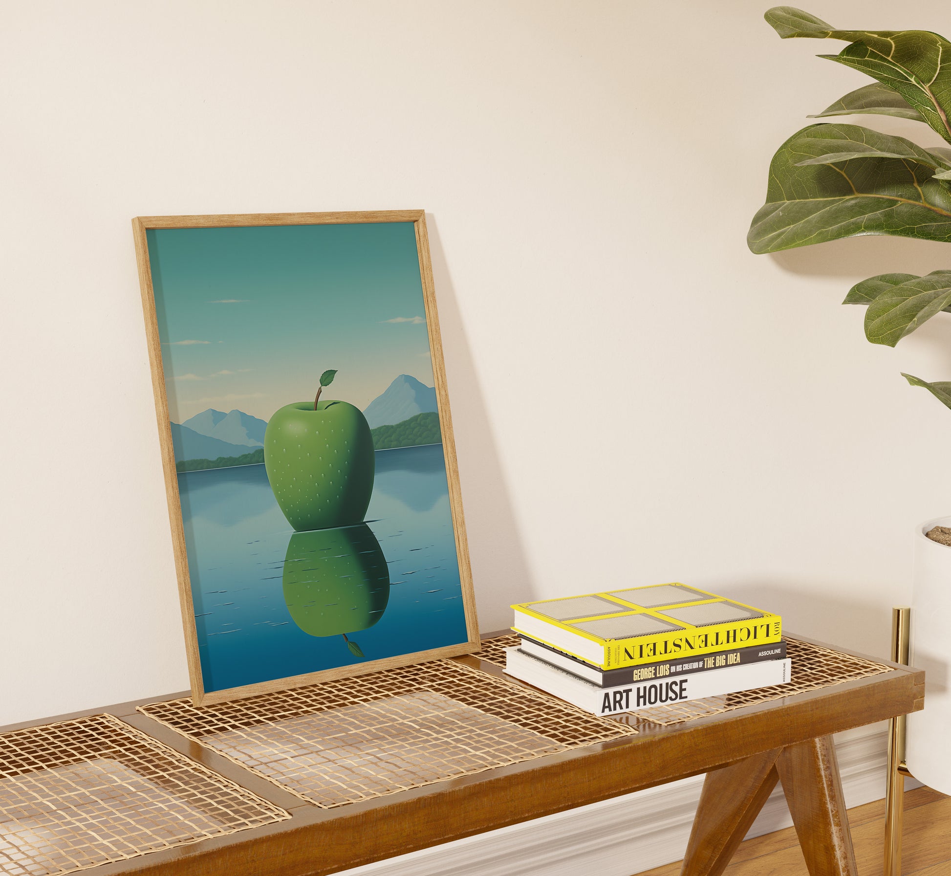A framed artwork of an apple reflected in water on a shelf with books.