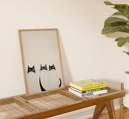 Illustration of two cats in a frame on a table beside books.