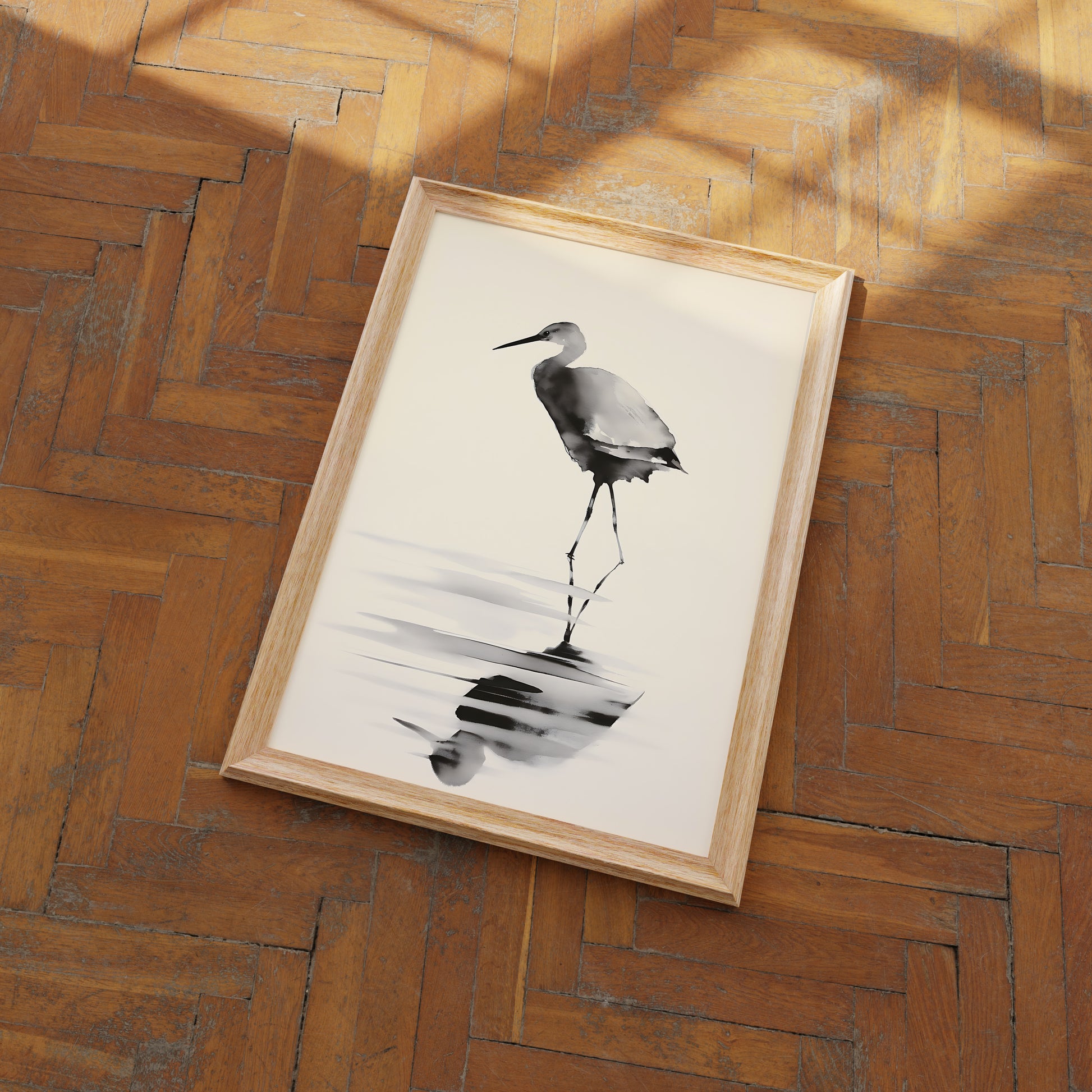 A framed painting of a heron on a wooden floor.