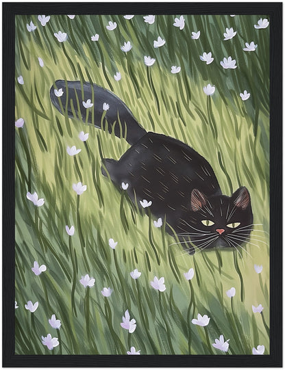 A painting of a black cat walking through a green field with white flowers, framed in wood.