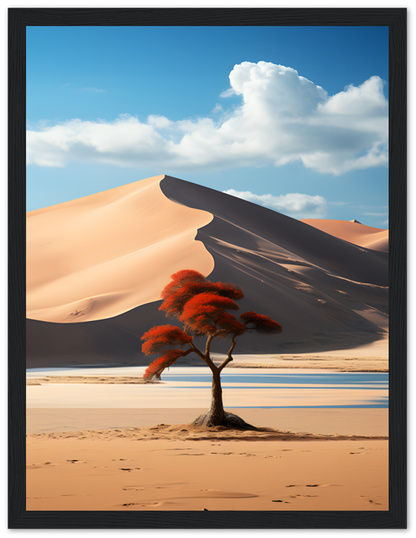 A framed painting of a solitary tree with red foliage in a desert with sand dunes and a blue sky.