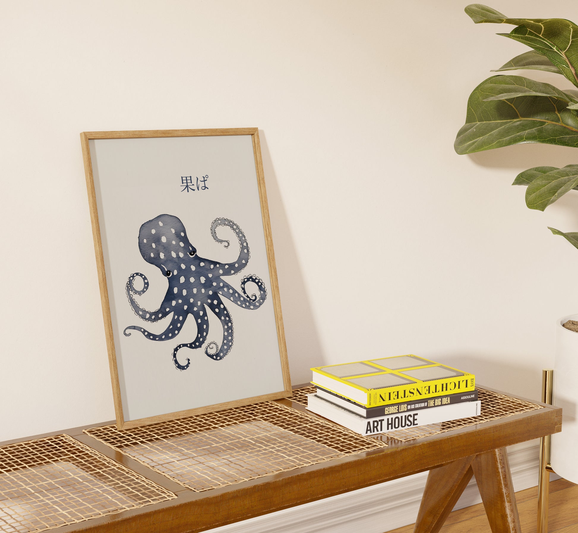 Framed octopus illustration on a shelf beside books and a plant.