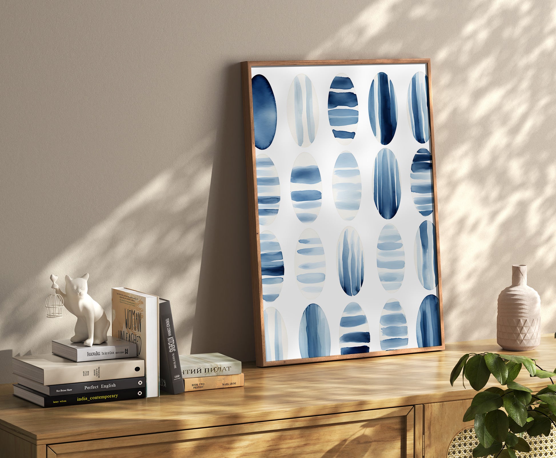 Modern art canvas with blue abstract design in a stylish room with decor items and books.