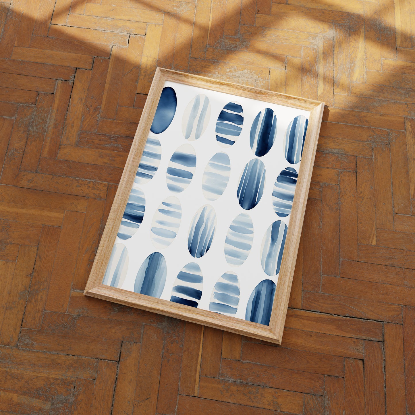 A framed abstract painting with blue and gray patterns on a wooden floor.