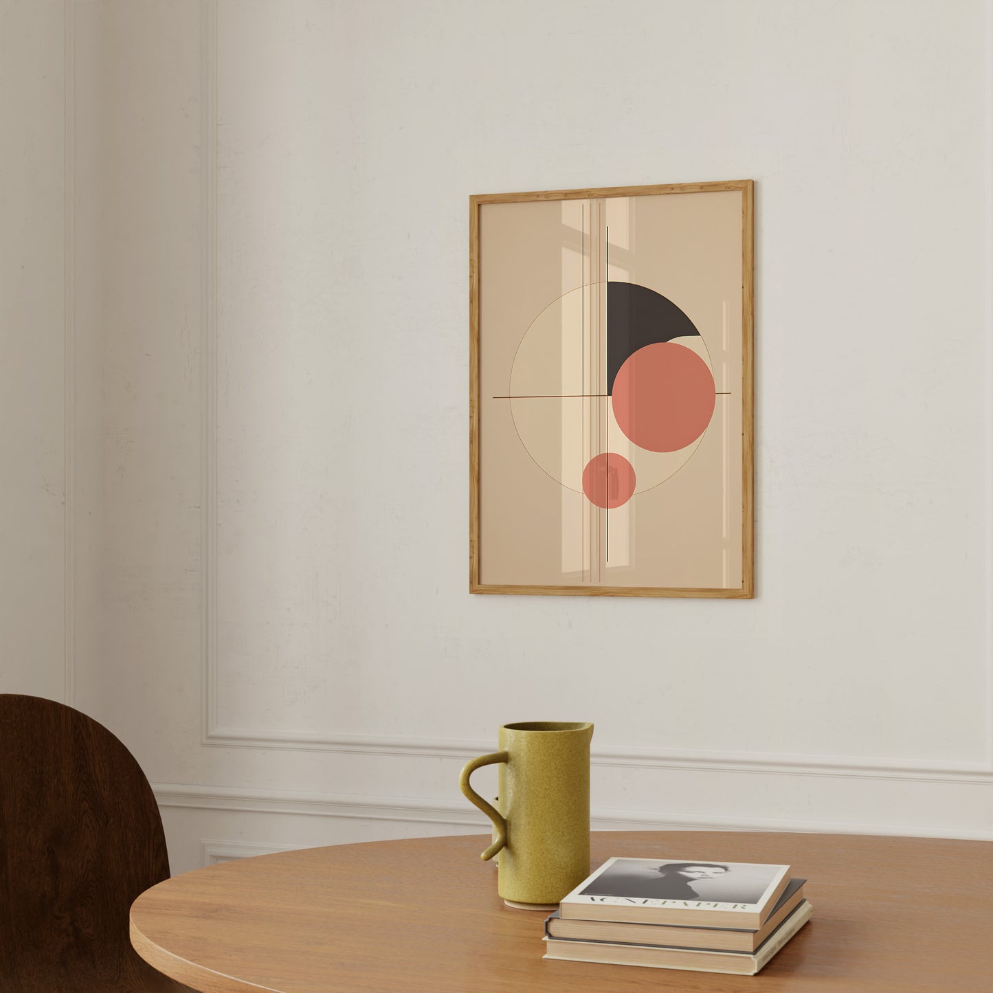 A modern art print above a table with a mustard mug and books in a serene room.