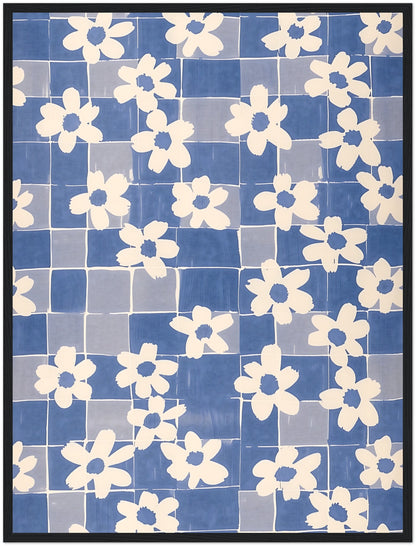 A framed textile art piece with a pattern of white flowers on a blue grid background.