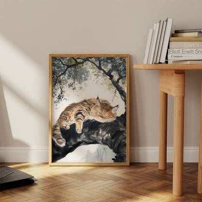 A framed painting of a sleeping cat on a branch by a window.