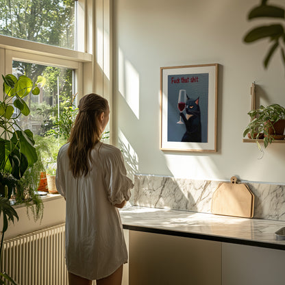 Woman looking at a framed picture with a humorous message in a sunny kitchen.