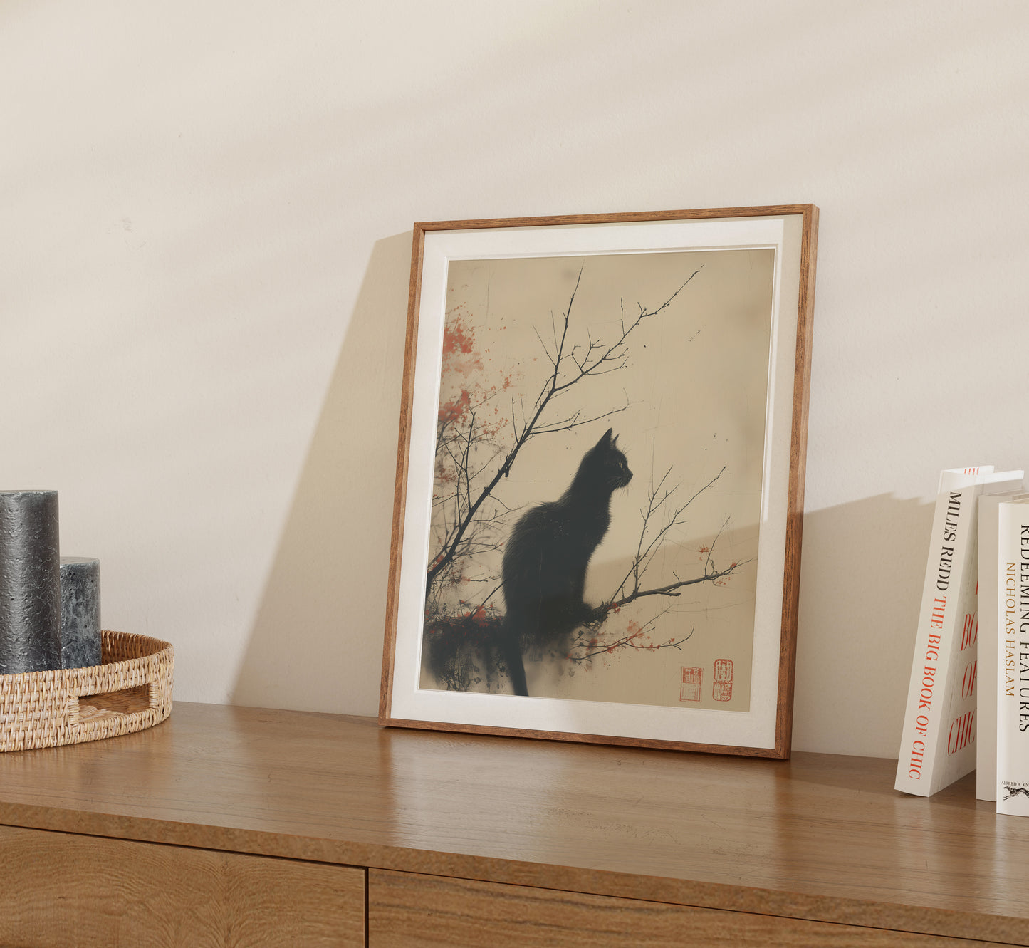 Framed artwork of a cat silhouette against a floral background on a shelf.