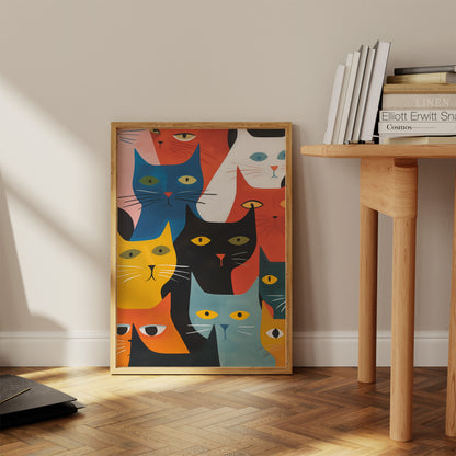 A colorful poster of stylized cats leaning against a wall in a sunlit room.
