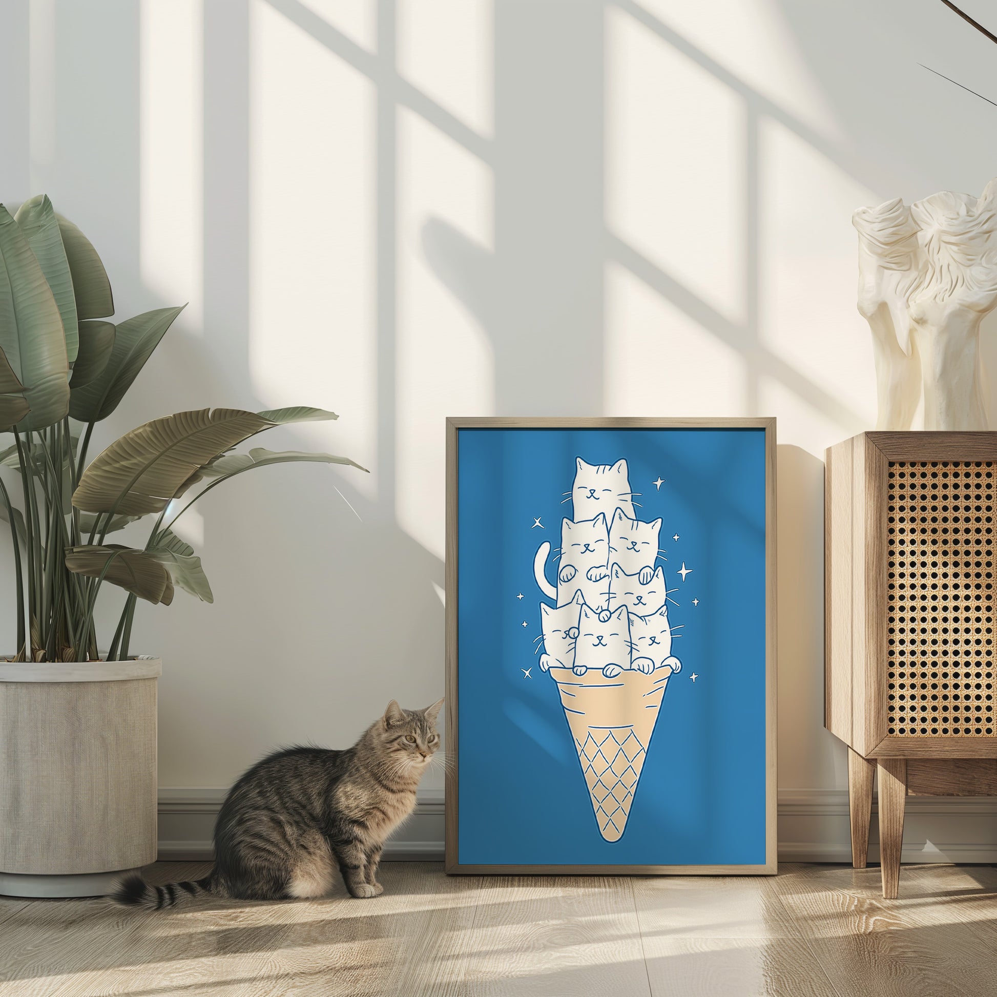 A cat looking at a framed picture of cats stacked in an ice-cream cone.