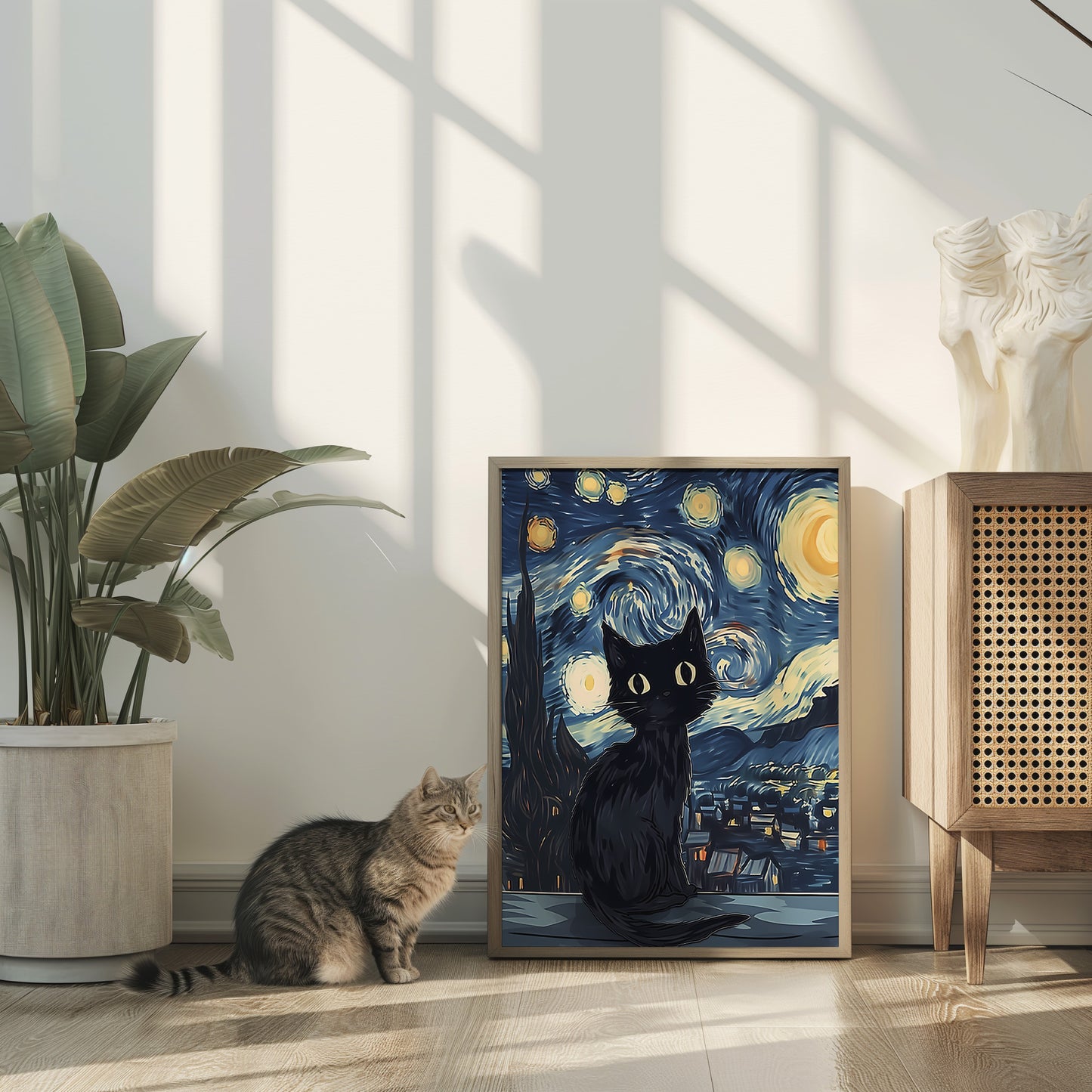 A real cat sitting next to a framed painting of a stylized black cat under a starry sky.