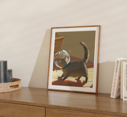A framed picture of a cat wearing an astronaut helmet on a shelf.