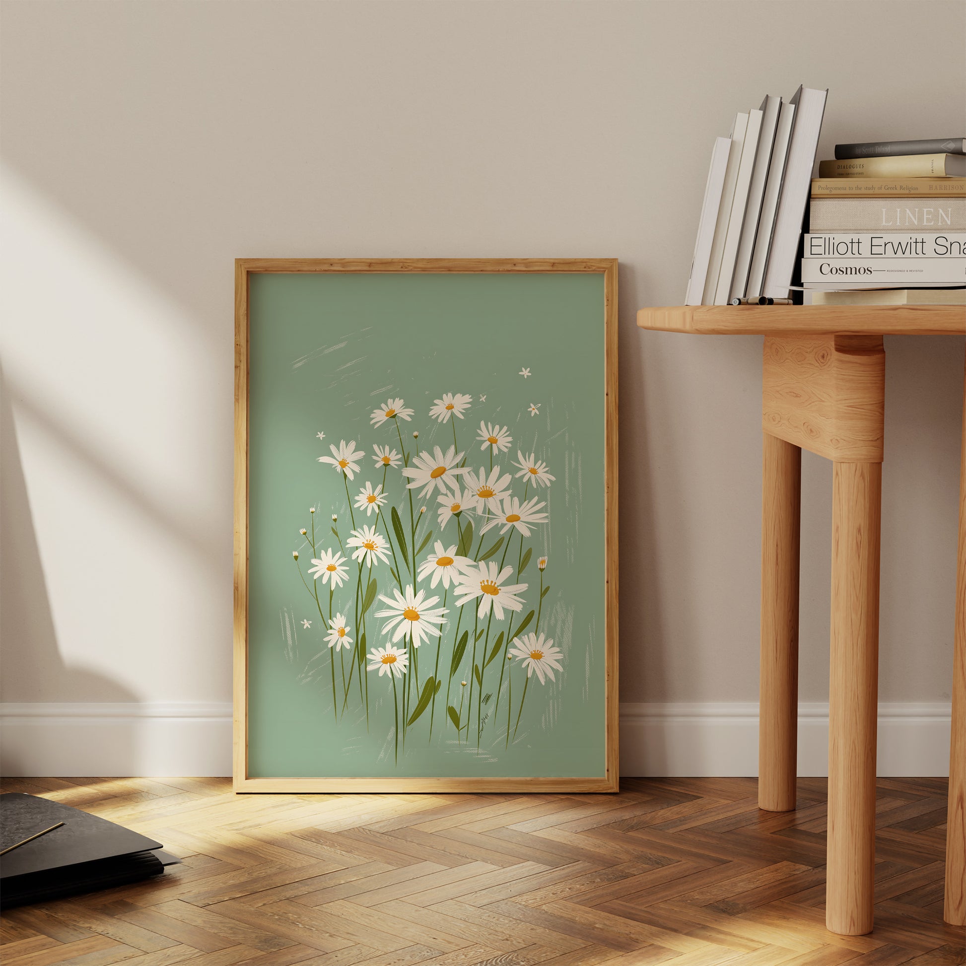 A framed painting of daisies leaning against a wall beside a wooden side table.