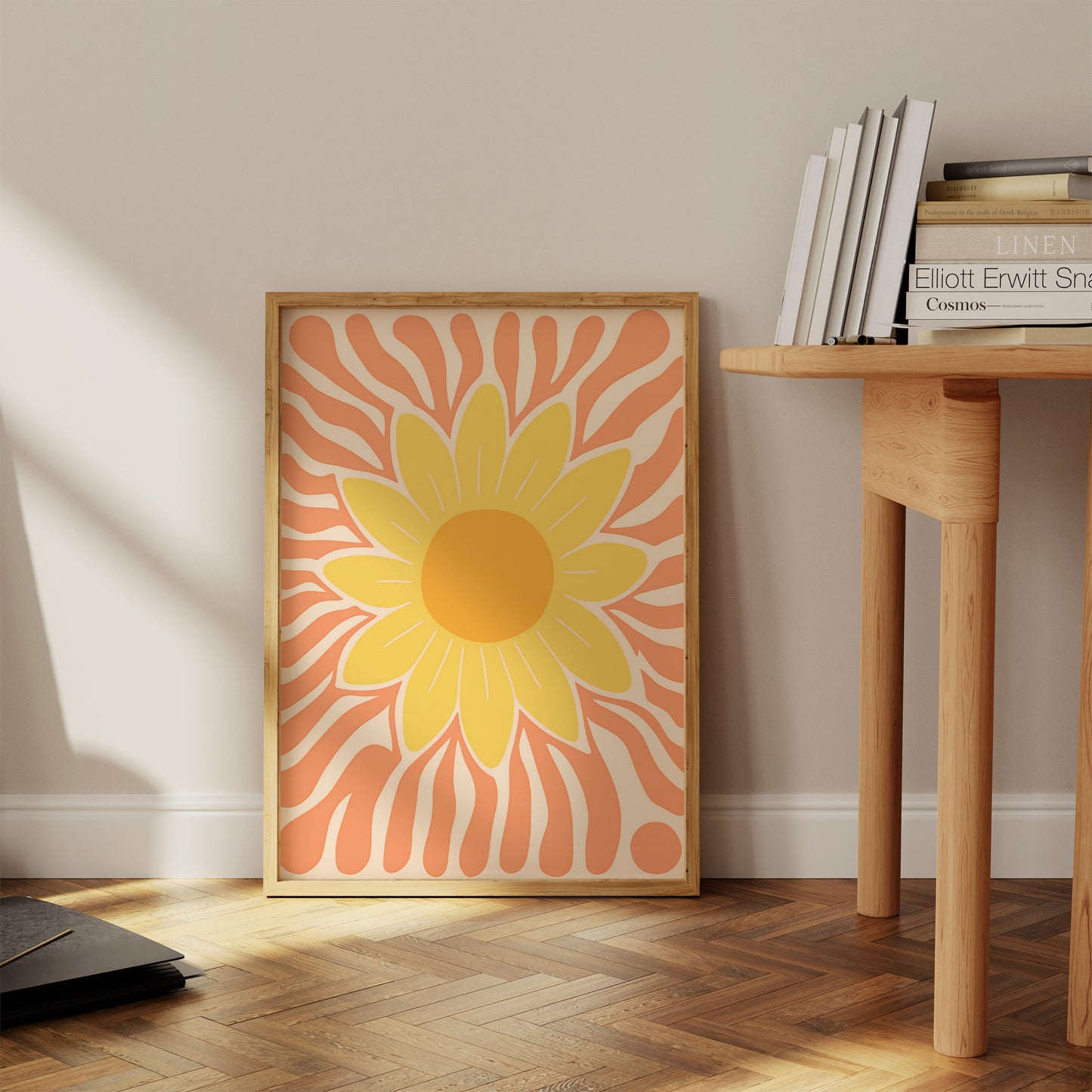 A framed illustration of a stylized sunflower leaning against a wall beside a wooden side table.