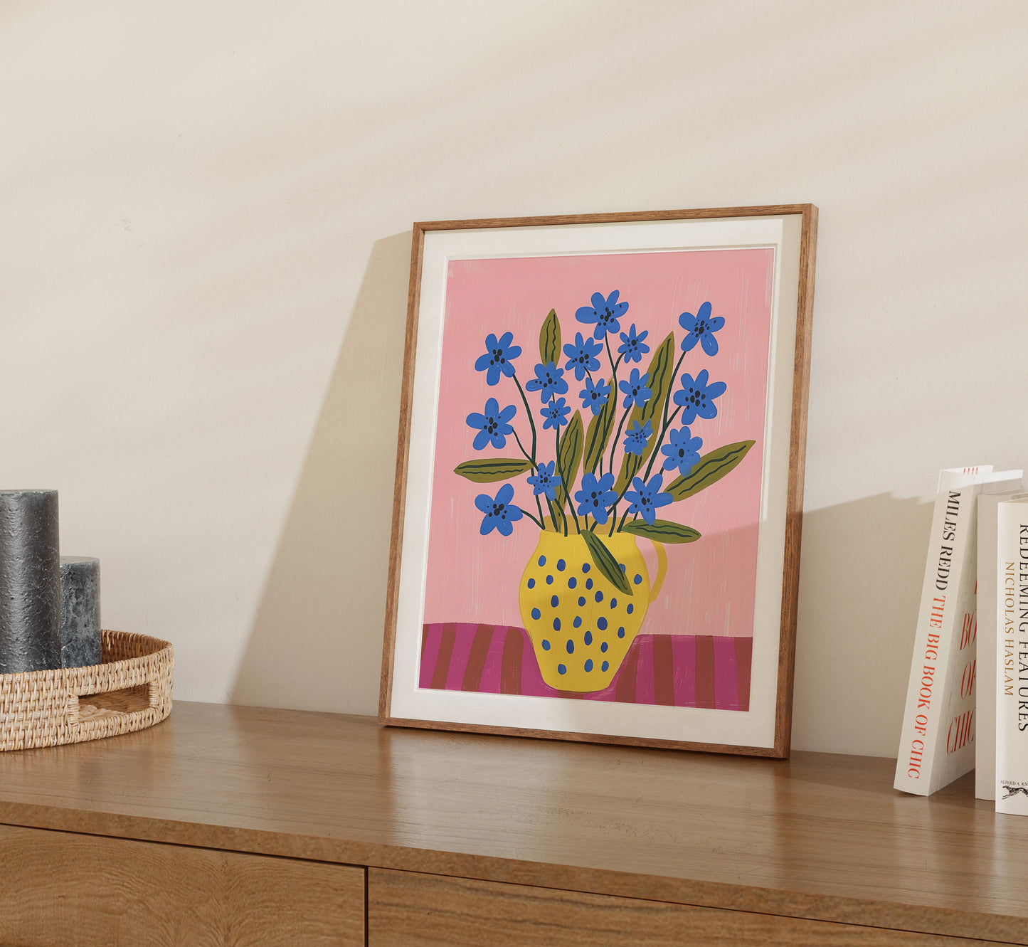 Illustration of blue flowers in a yellow vase framed and displayed on a shelf