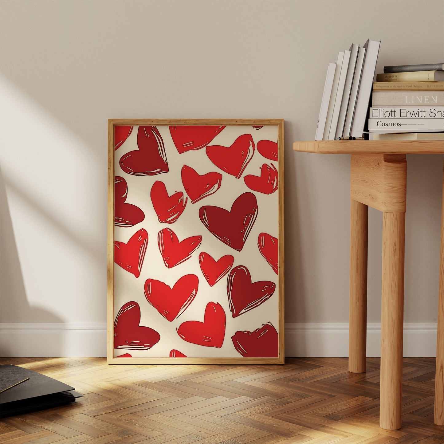 Art print with red hearts on a cream background leaning against a wall in a room with wooden floor.