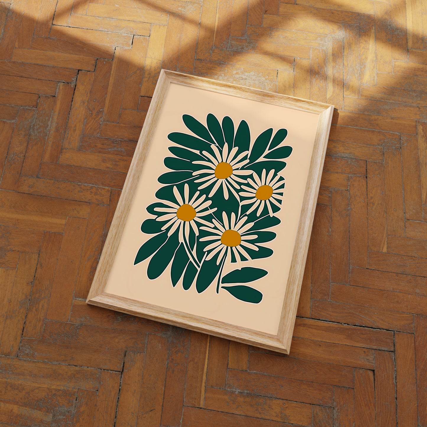 A framed picture of a floral design on a wooden floor.